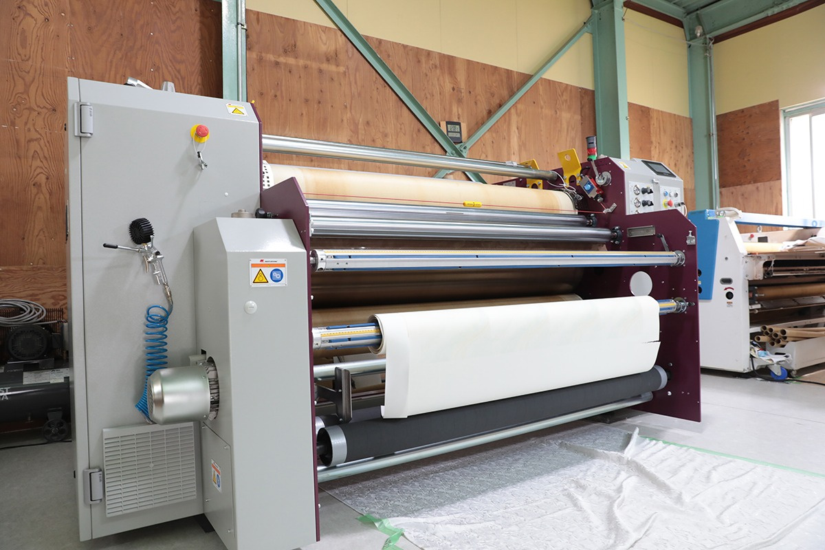 Transferring from transfer paper to fabric while controlling conditions to suit the fabric and material using a TRAPIS exclusive transfer machine.
